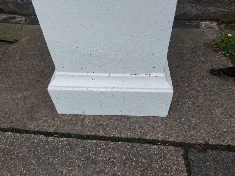 A classical white painted garden urn featuring an acanthus leaf pattern and scalloped rim, positioned on a matching square pedestal stand. View VII