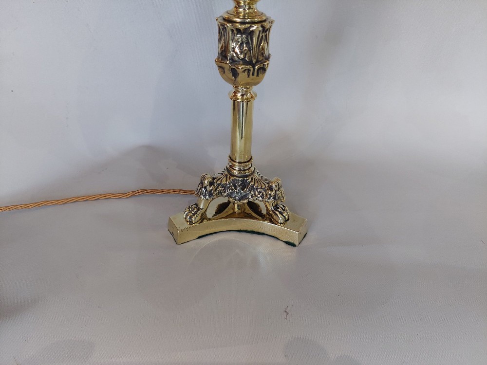 A pair of early 19th-century brass candlestick table lamps with claw feet and rose-coloured fringed fabric shades. View II