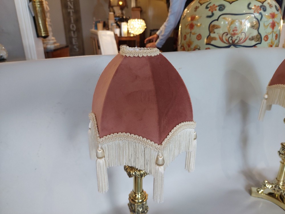 A pair of early 19th-century brass candlestick table lamps with claw feet and rose-coloured fringed fabric shades. View V