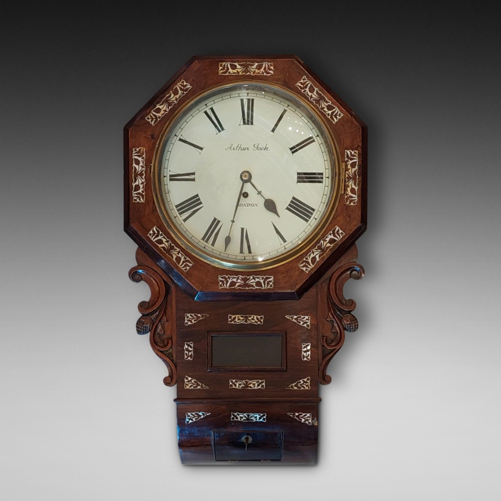 A Victorian octagonal rosewood wall clock featuring intricate floral mother-of-pearl inlay, carved side scrolls, and an off-white dial with Roman numerals.