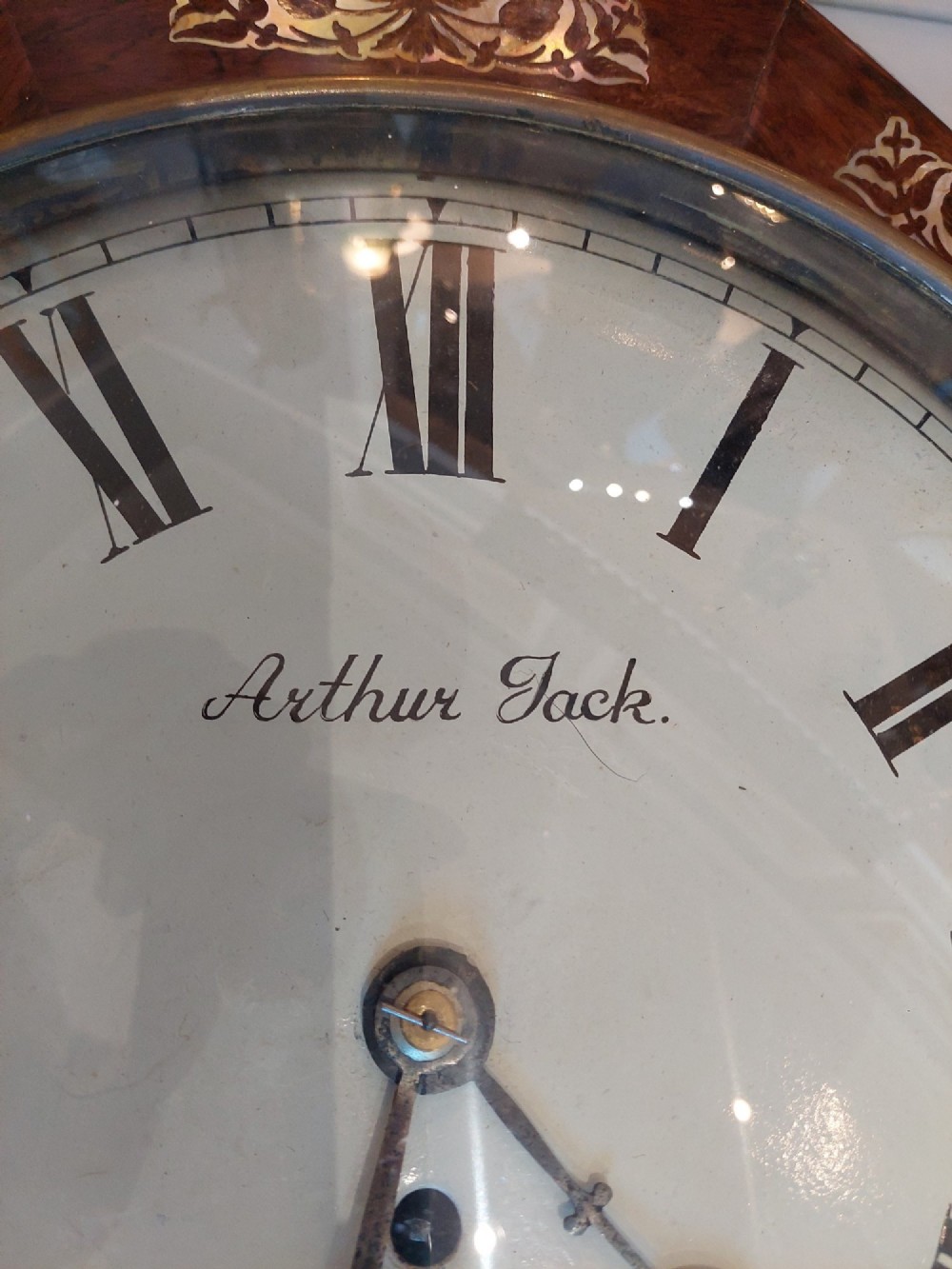 A Victorian octagonal rosewood wall clock featuring intricate floral mother-of-pearl inlay, carved side scrolls, and an off-white dial with Roman numerals. View IV
