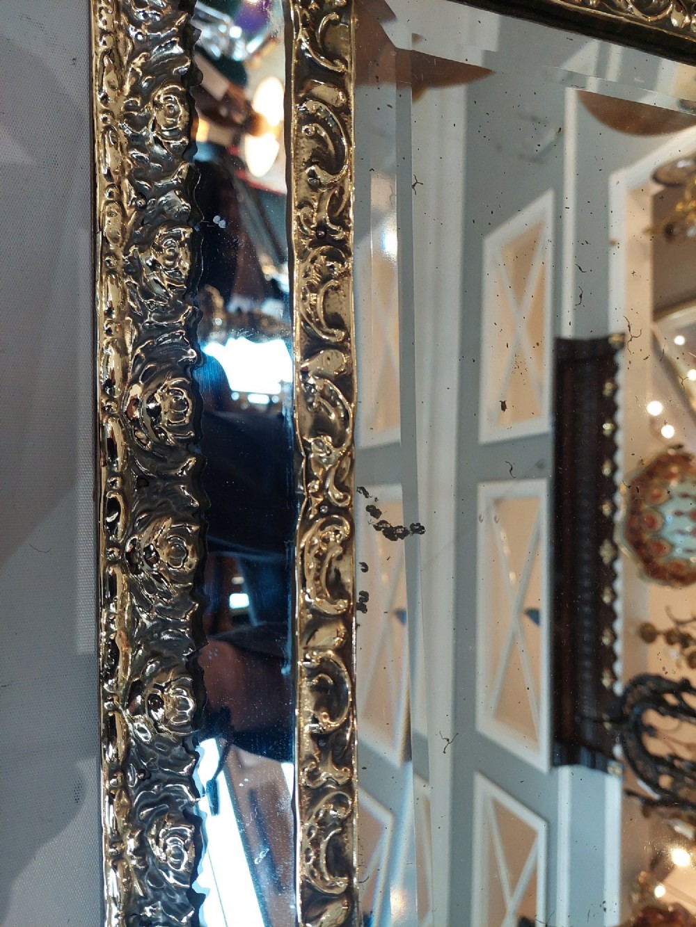 An antique 19th-century French rectangular wall mirror featuring an embossed pressed brass frame with a decorated triangular crest and mirrored border surround. View II