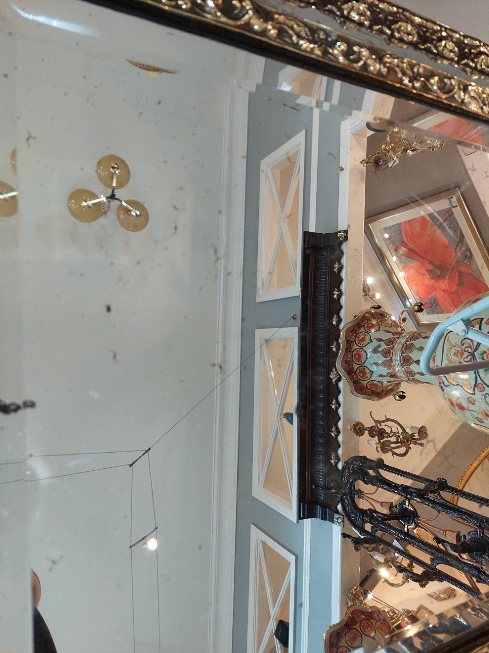 An antique 19th-century French rectangular wall mirror featuring an embossed pressed brass frame with a decorated triangular crest and mirrored border surround. View III