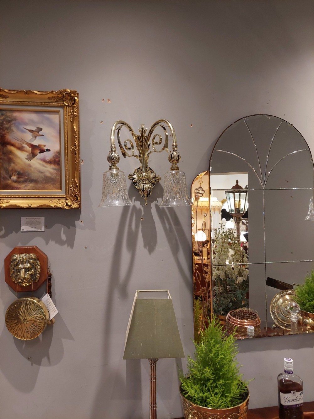 A pair of Edwardian cast brass double-arm wall sconces featuring leaf backplates and cut glass bell-shaped shades. View II