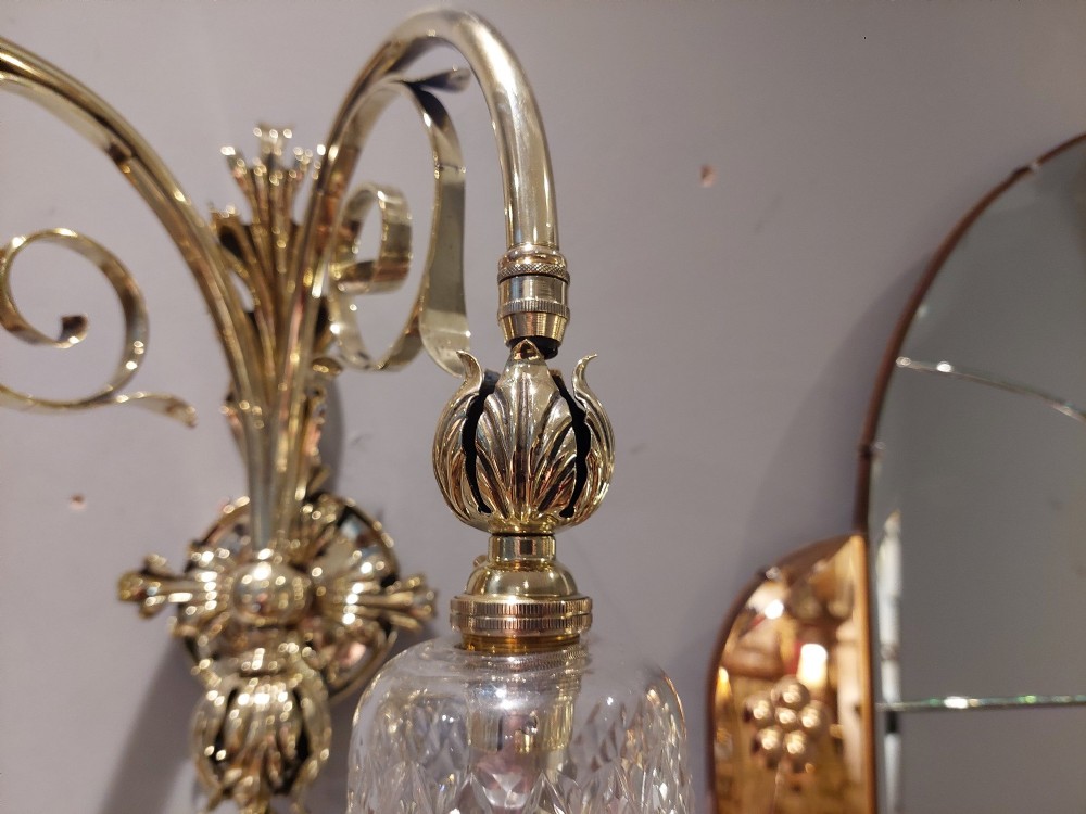 A pair of Edwardian cast brass double-arm wall sconces featuring leaf backplates and cut glass bell-shaped shades. View III