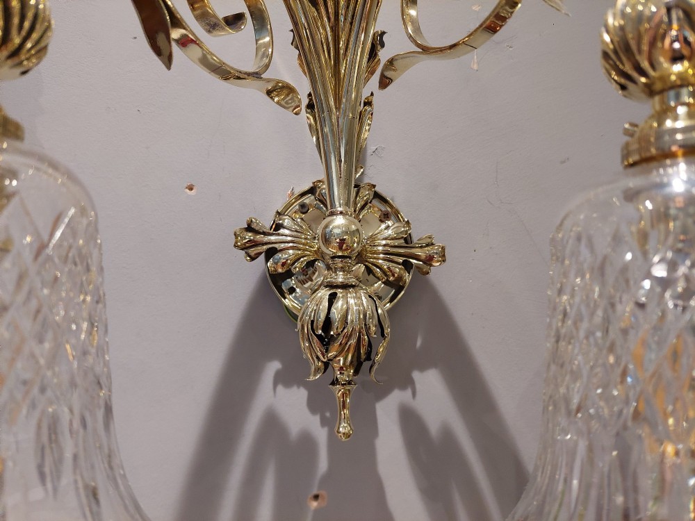 A pair of Edwardian cast brass double-arm wall sconces featuring leaf backplates and cut glass bell-shaped shades. View IV