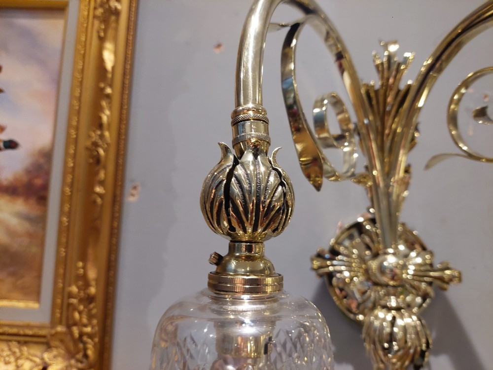 A pair of Edwardian cast brass double-arm wall sconces featuring leaf backplates and cut glass bell-shaped shades. View V