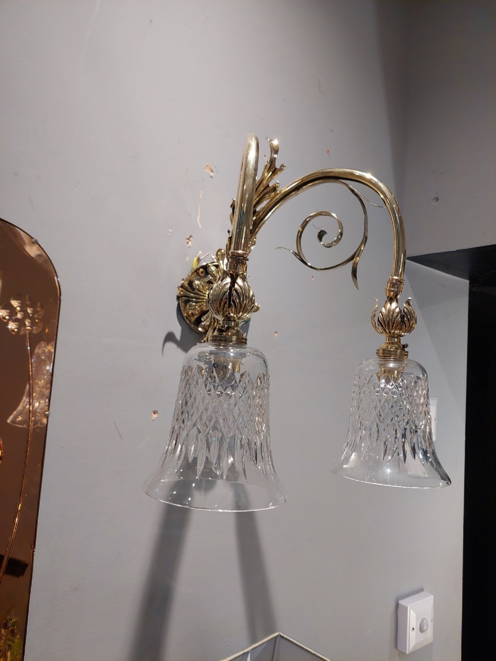 A pair of Edwardian cast brass double-arm wall sconces featuring leaf backplates and cut glass bell-shaped shades. View IX
