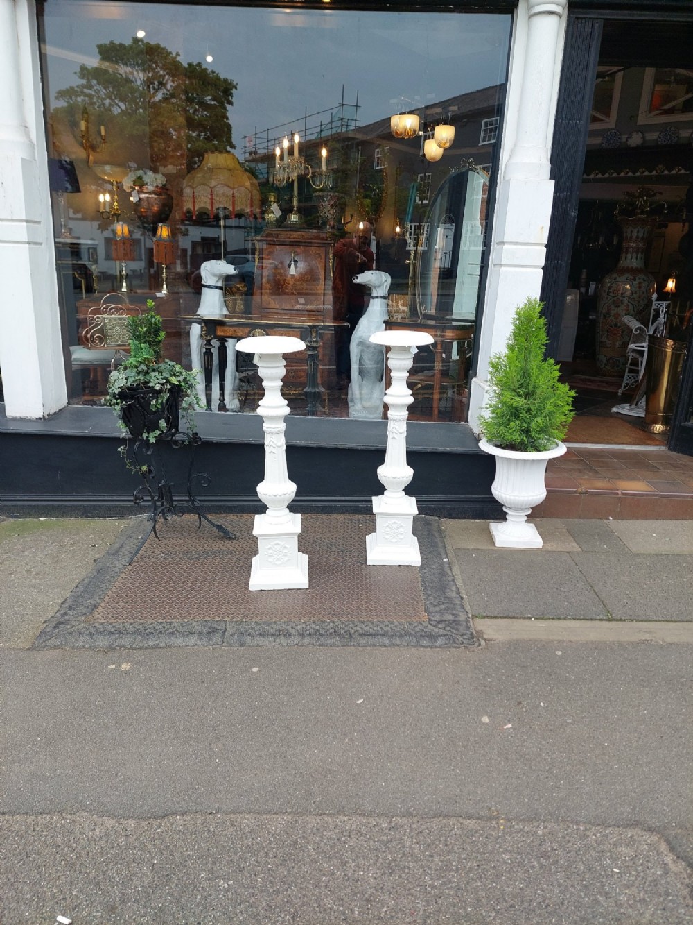 A pair of late 19th-century white painted cast iron garden pedestals with turned column shafts and floral relief square bases. View II