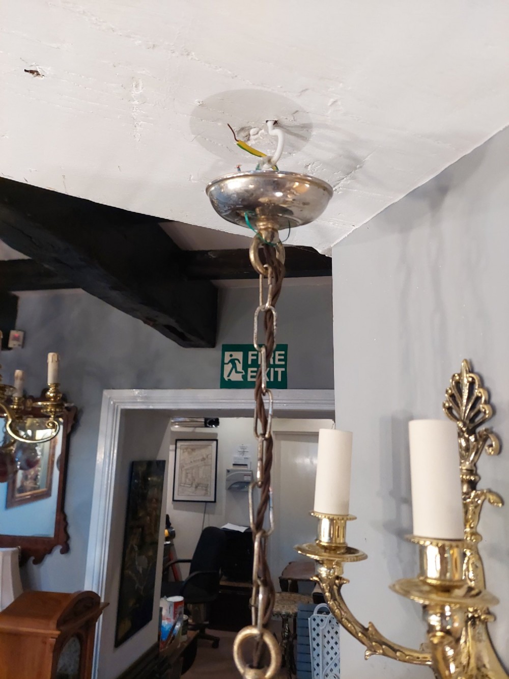 A 1920s cream glass pendant light shade hand painted with blue floral motifs, suspended from a brass chain. View III