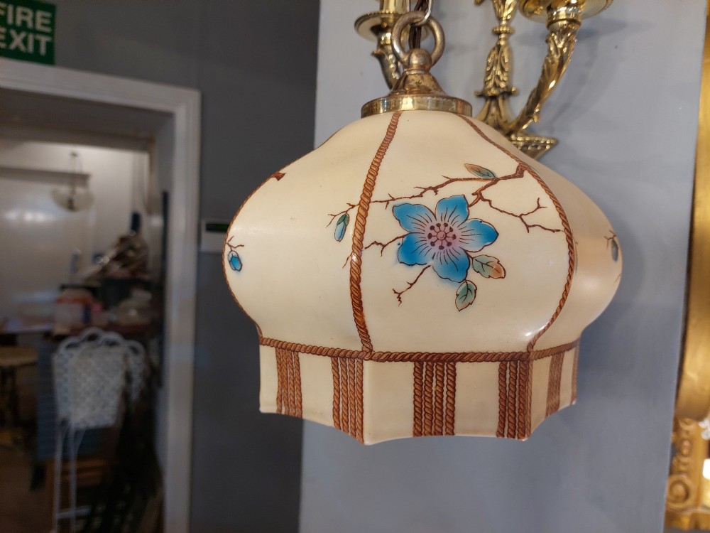 A 1920s cream glass pendant light shade hand painted with blue floral motifs, suspended from a brass chain. View VI