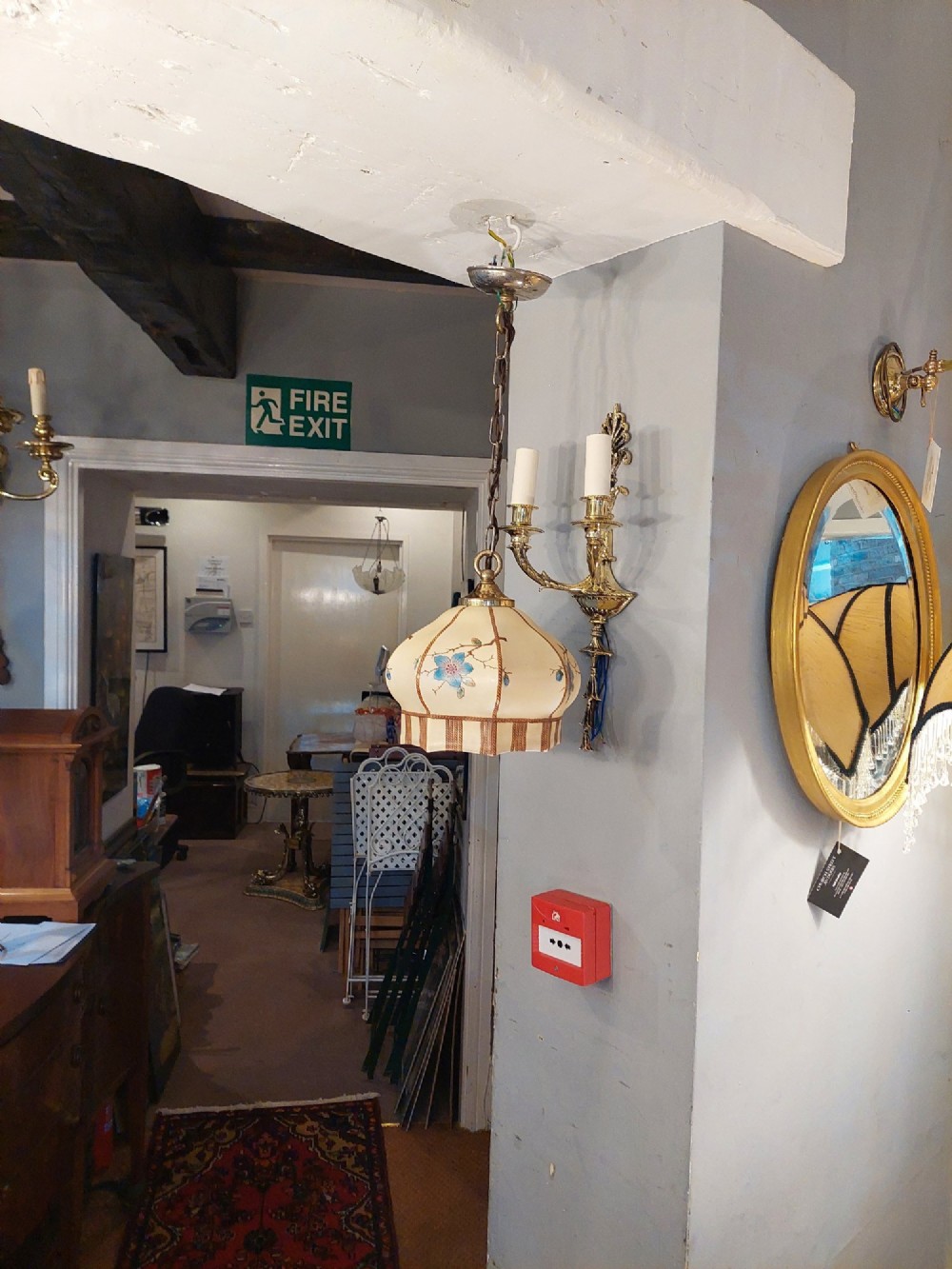 A 1920s cream glass pendant light shade hand painted with blue floral motifs, suspended from a brass chain. View VIII
