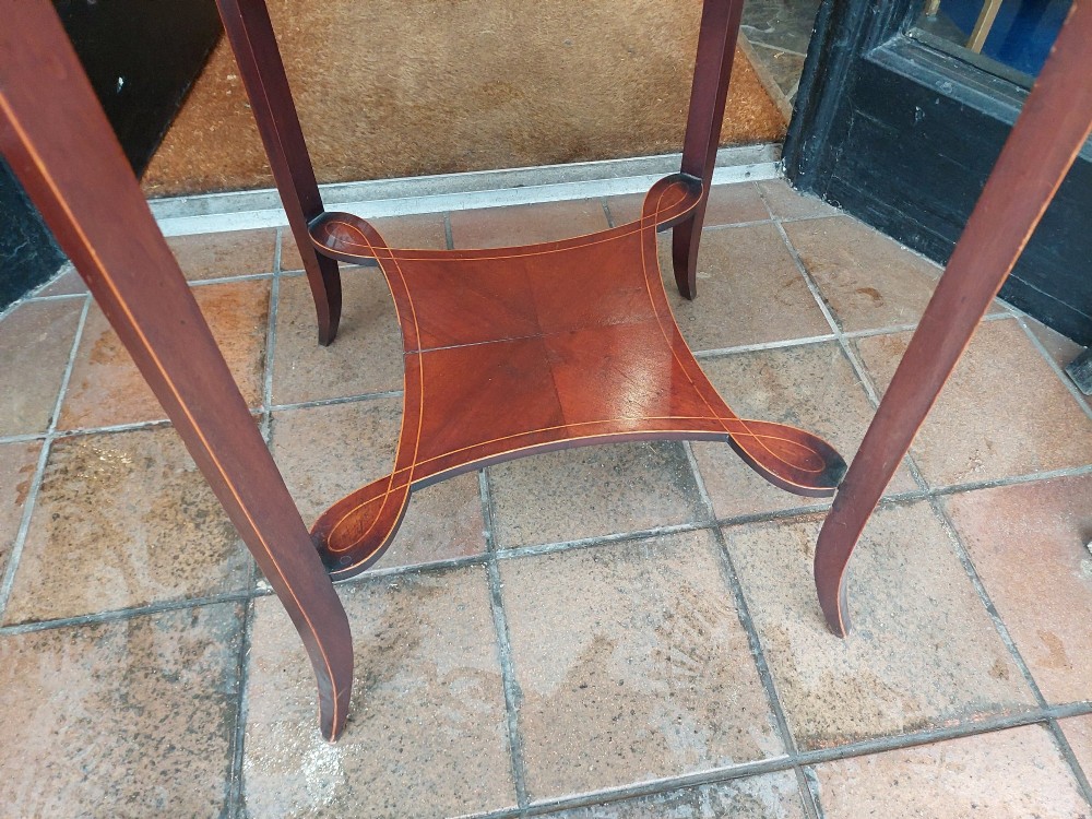A circular Edwardian mahogany occasional table featuring a segmented veneer top with boxwood stringing inlay, splayed legs, and a lower concave stretcher shelf. View III