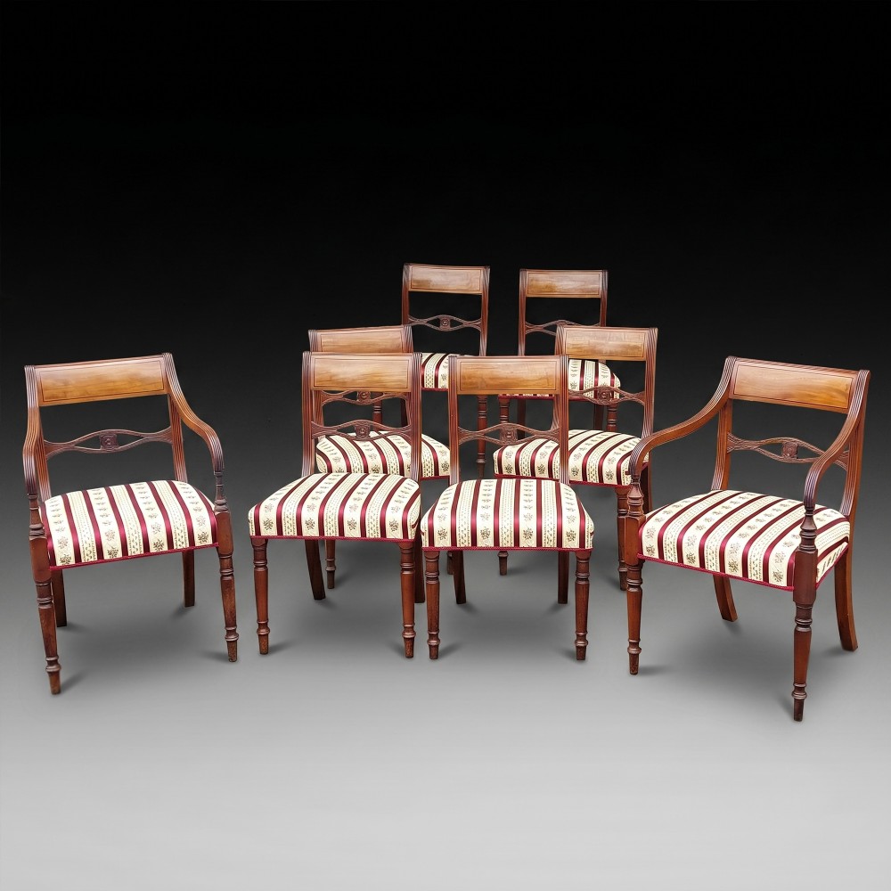 A Regency mahogany extendable dining table surrounded by matching dining chairs with striped upholstered seats. View II