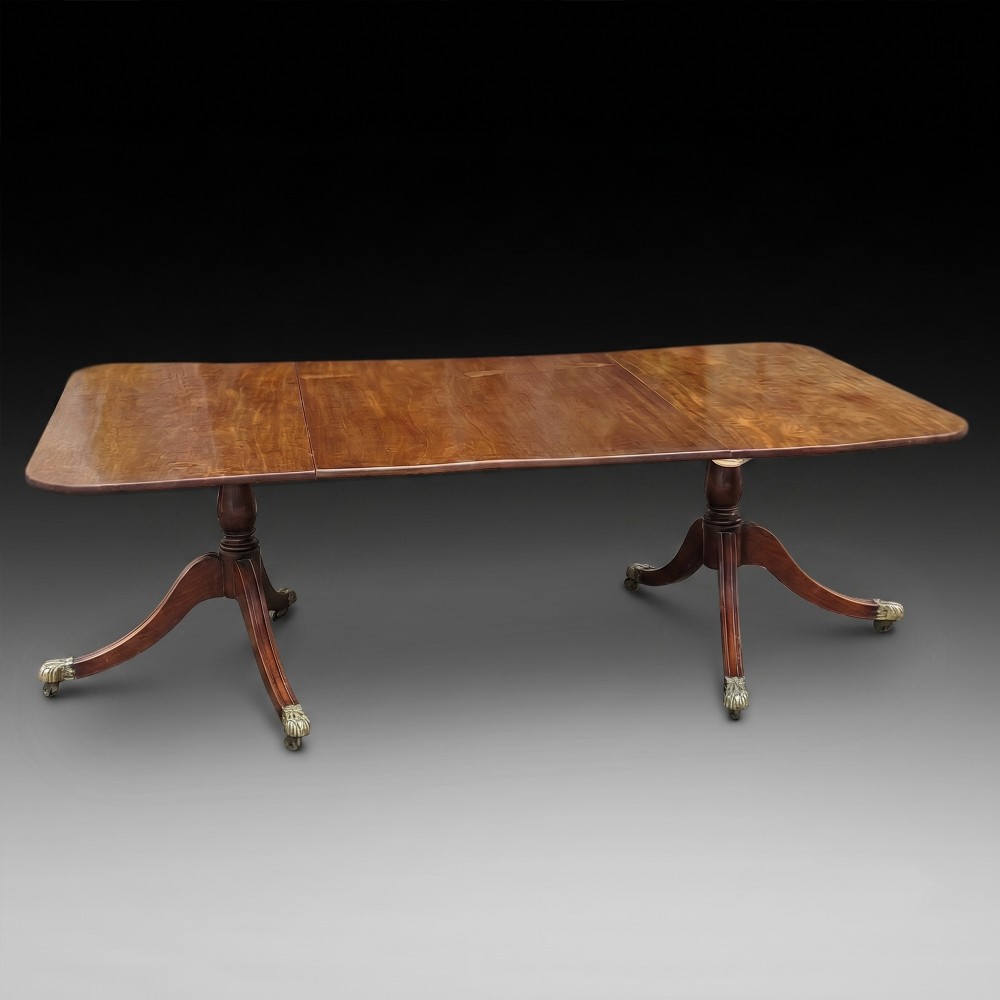A Regency mahogany extendable dining table surrounded by matching dining chairs with striped upholstered seats. View III