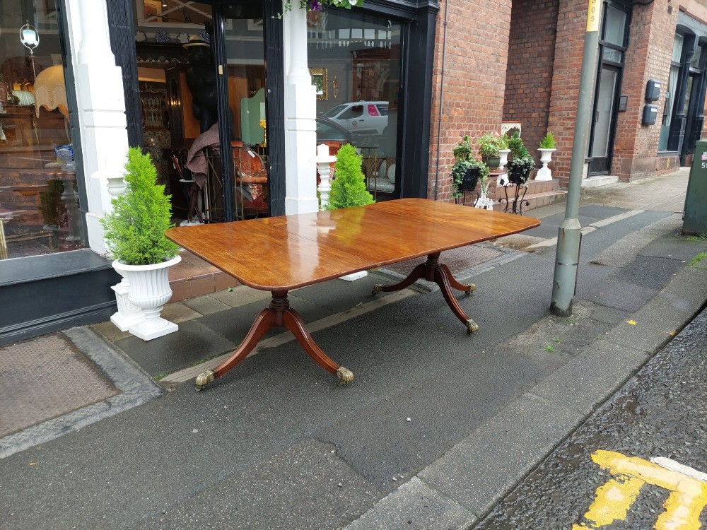 A Regency mahogany extendable dining table surrounded by matching dining chairs with striped upholstered seats. View XI