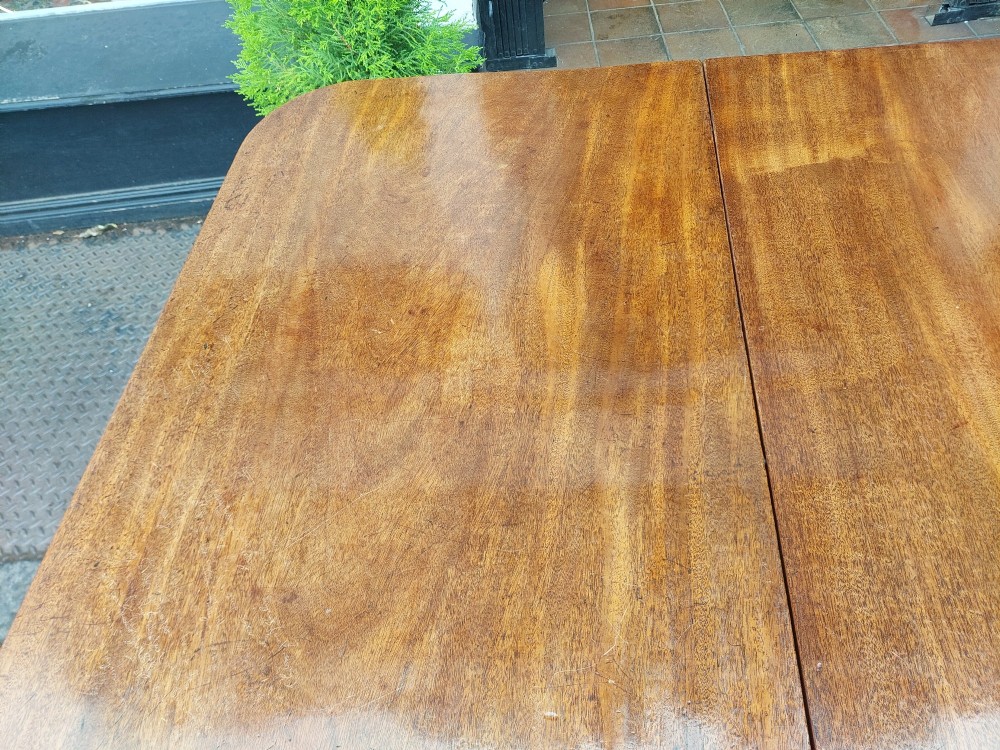 A Regency mahogany extendable dining table surrounded by matching dining chairs with striped upholstered seats. View XII