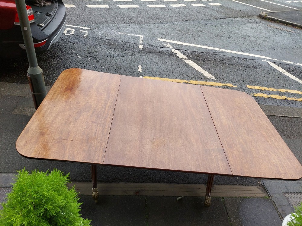 A Regency mahogany extendable dining table surrounded by matching dining chairs with striped upholstered seats. View XIV