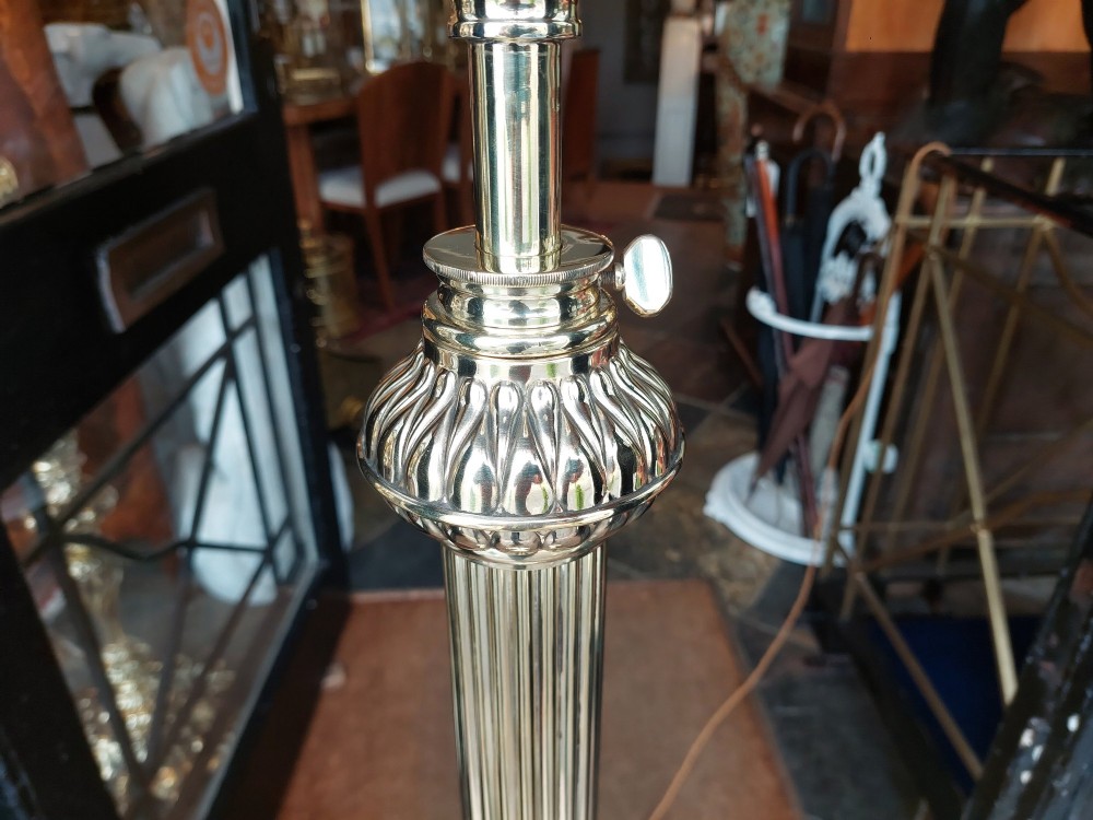 A Victorian brass extending standard floor lamp featuring a fluted column base and a deep red fabric shade with fringe detailing. View II