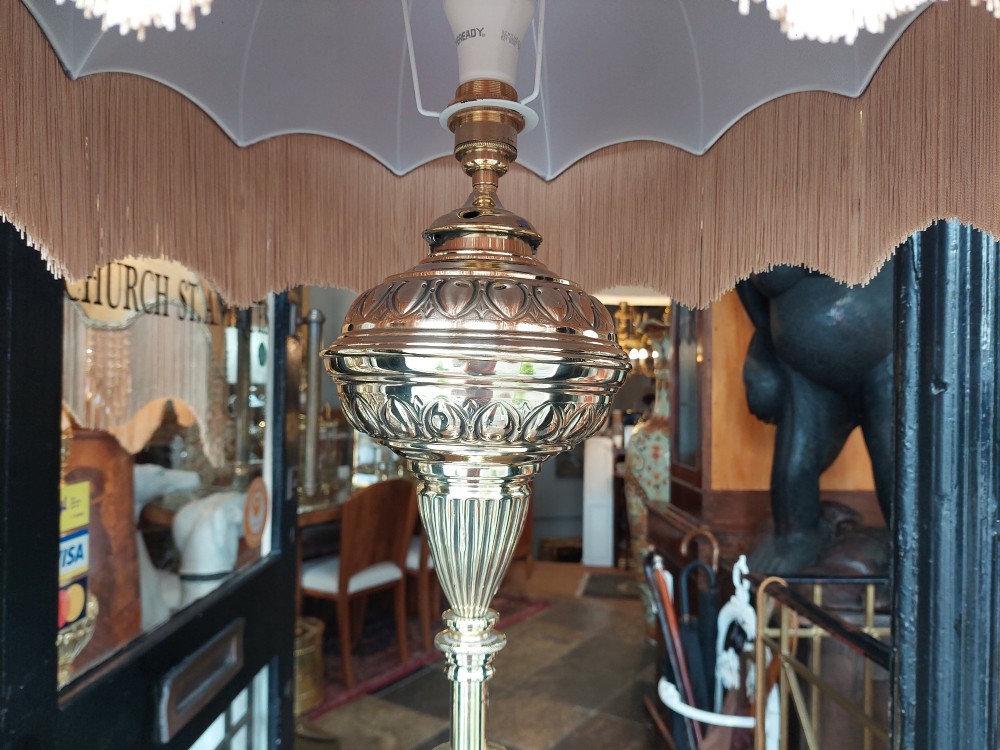 A Victorian brass extending standard floor lamp featuring a fluted column base and a deep red fabric shade with fringe detailing. View V