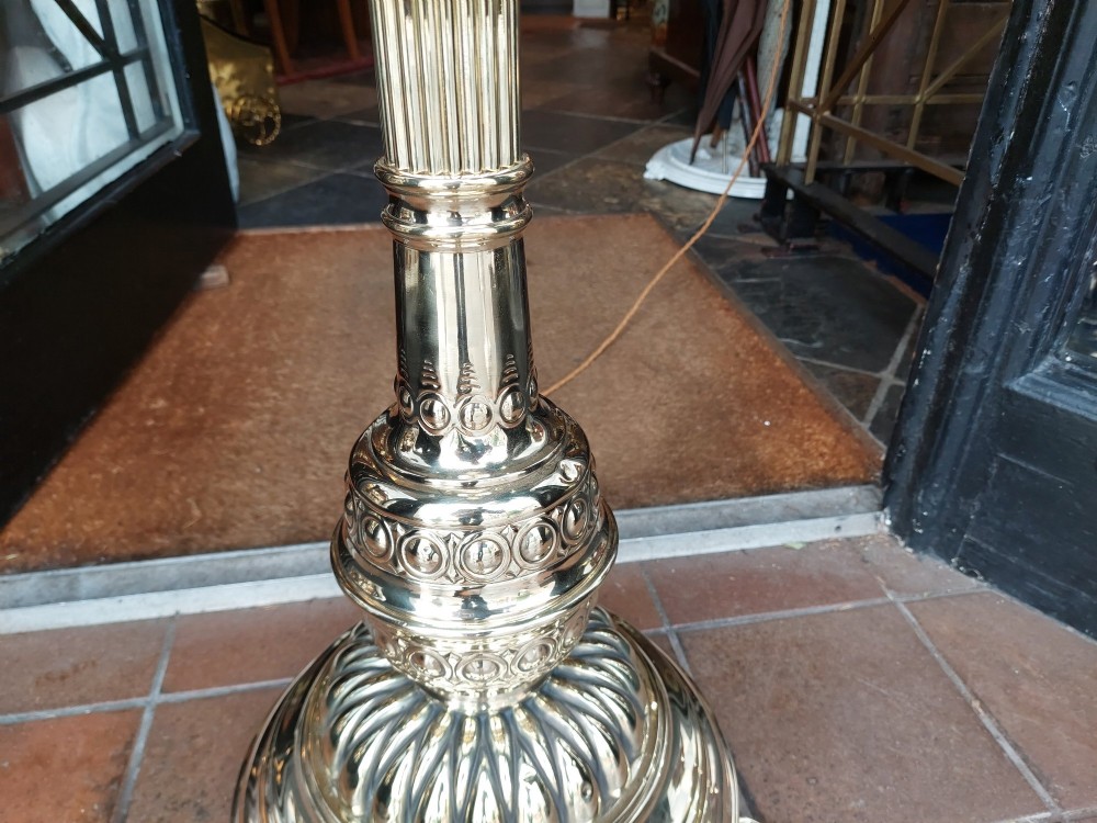 A Victorian brass extending standard floor lamp featuring a fluted column base and a deep red fabric shade with fringe detailing. View VII