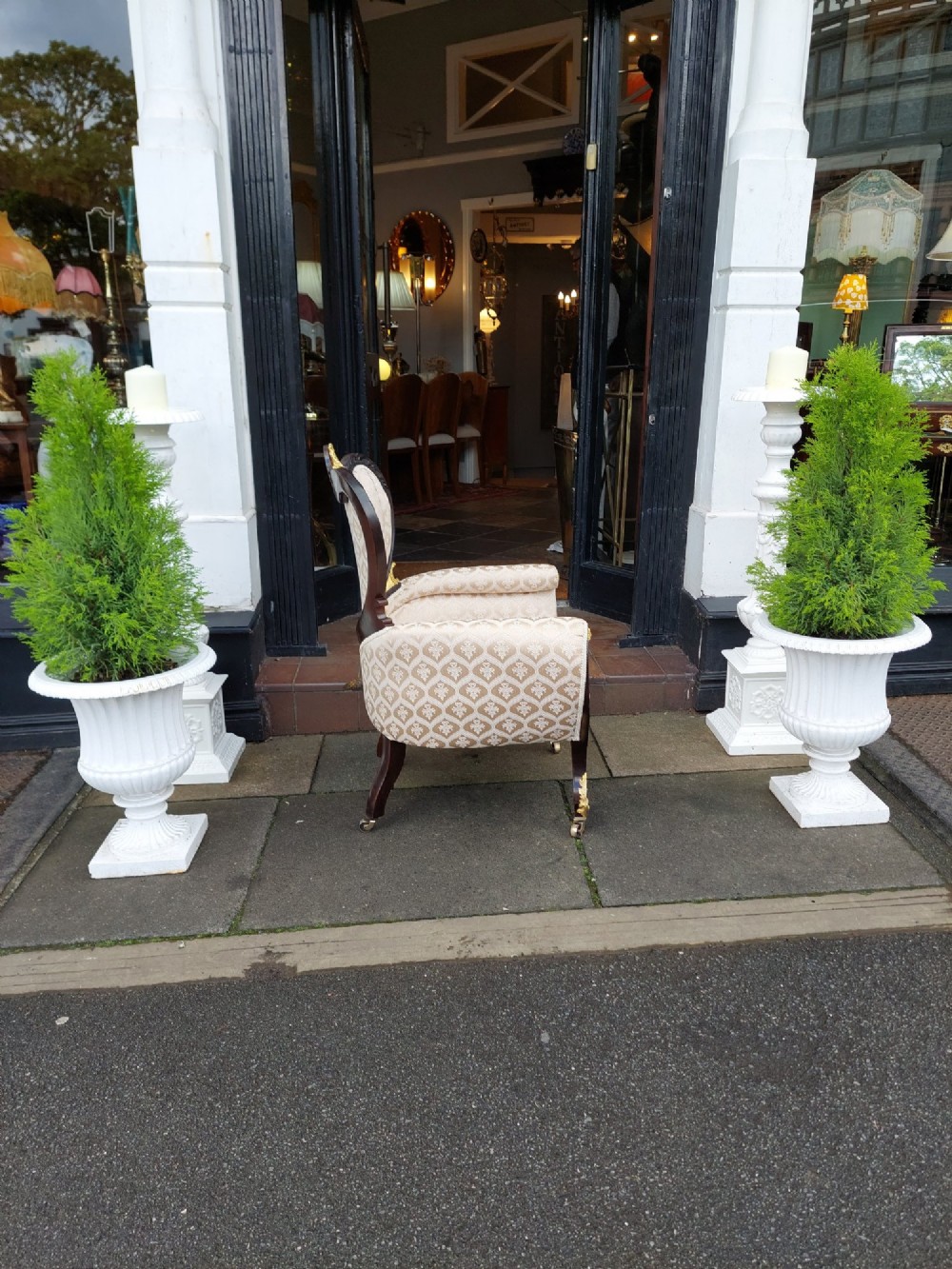 An upholstered French Empire style mahogany armchair featuring gilt bronze mounts, a channelled backrest, cream fabric, and brass castors. View VIII
