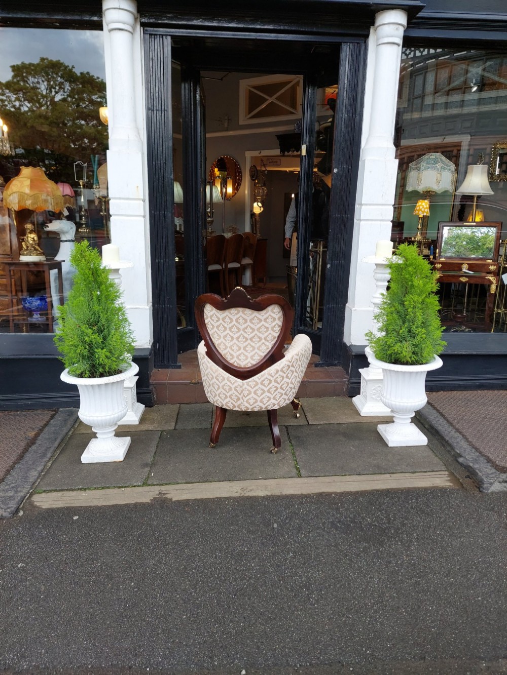 An upholstered French Empire style mahogany armchair featuring gilt bronze mounts, a channelled backrest, cream fabric, and brass castors. View IX