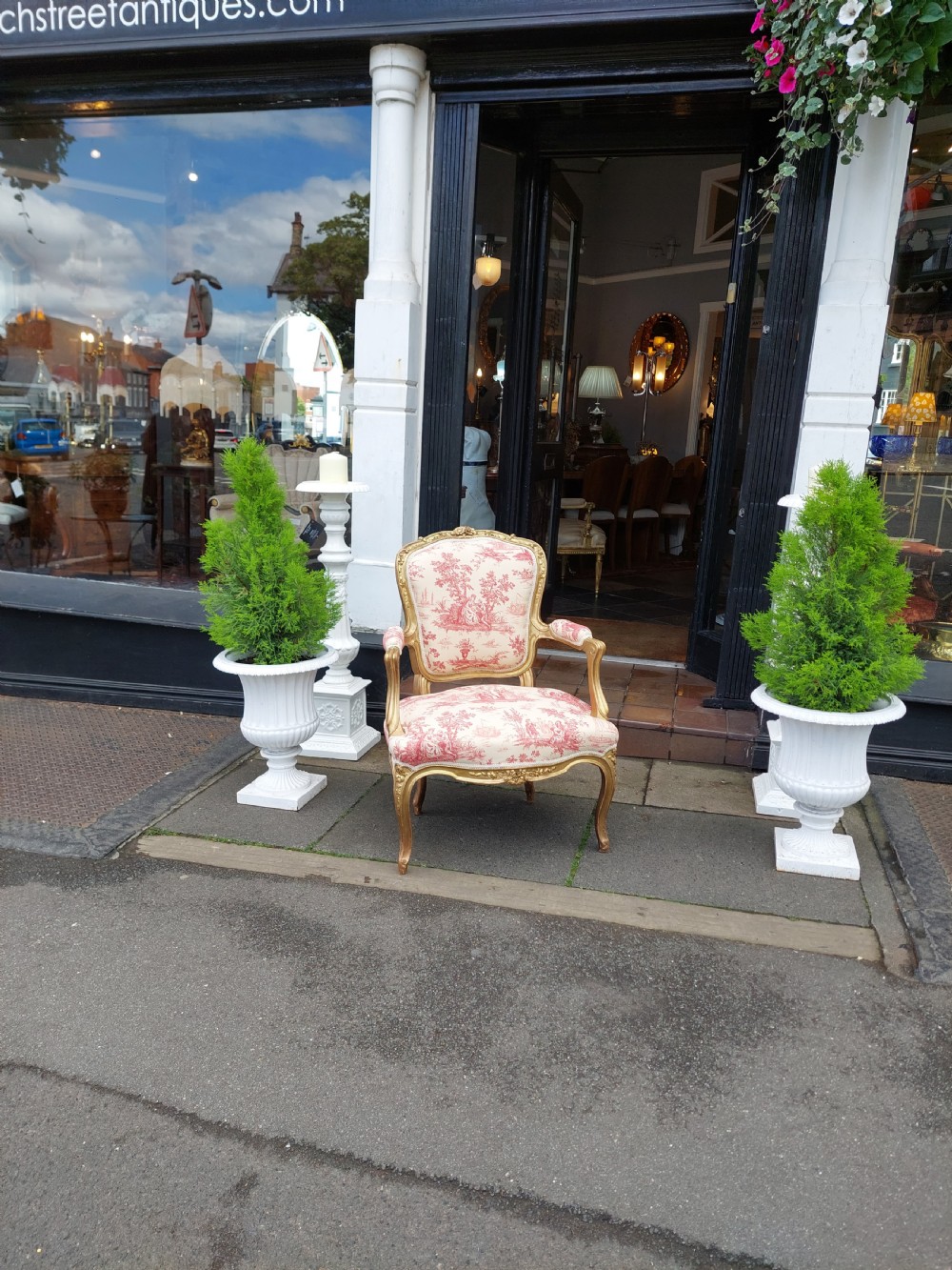 A late 19th-century French Rococo Revival giltwood open armchair upholstered in red and white Toile de Jouy patterned fabric featuring cabriole legs and floral carvings. View III
