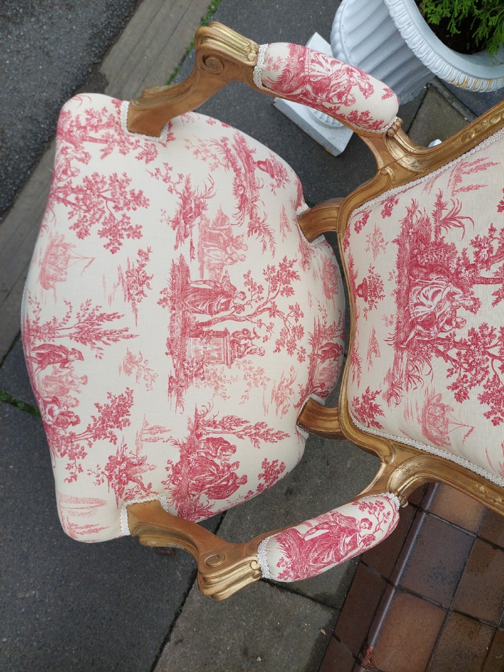 A late 19th-century French Rococo Revival giltwood open armchair upholstered in red and white Toile de Jouy patterned fabric featuring cabriole legs and floral carvings. View VI