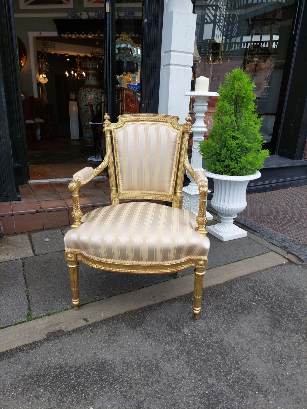 A mid-Victorian giltwood fauteuil armchair with carved golden wood framing, fluted legs, and cream striped upholstery. View II