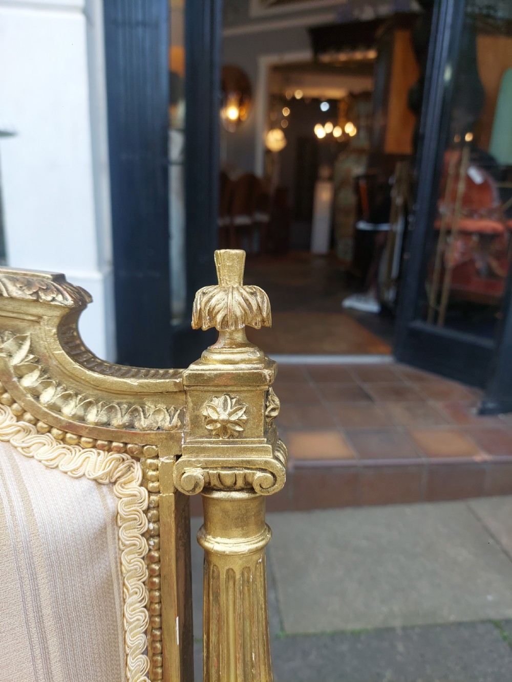 A mid-Victorian giltwood fauteuil armchair with carved golden wood framing, fluted legs, and cream striped upholstery. View V