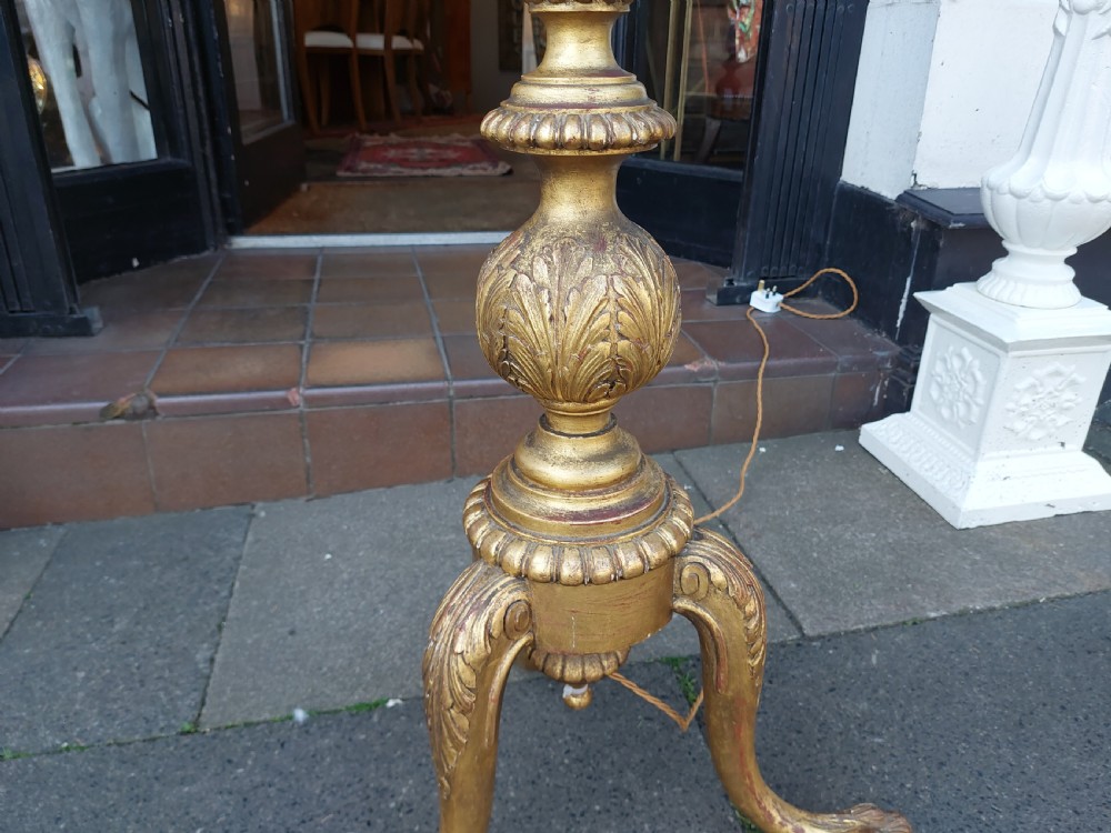 A tall Neoclassical giltwood standard lamp featuring a reeded column, an urn knop, carved tripod legs, and a fabric shade with tasselled fringe. View IV