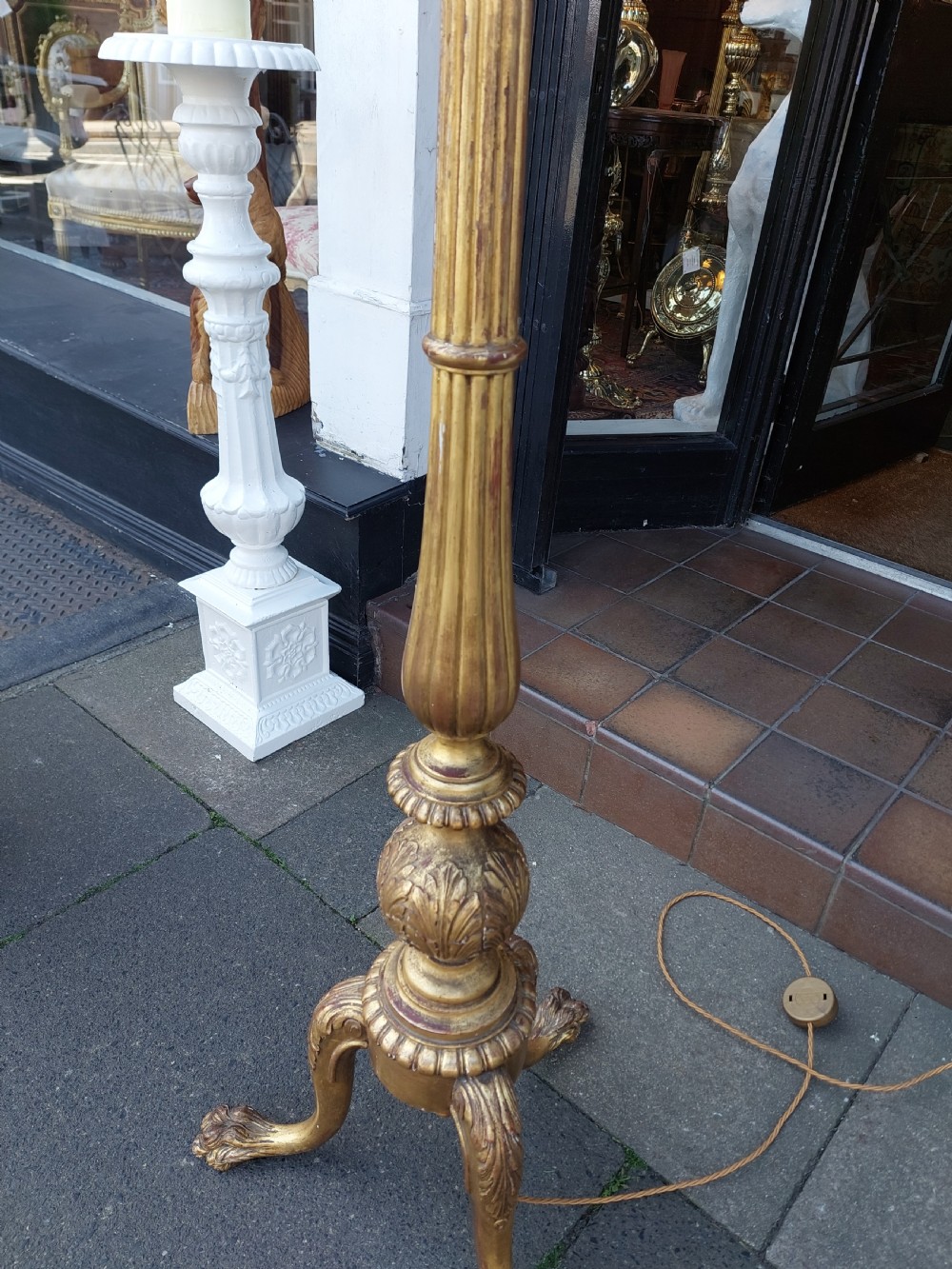 A tall Neoclassical giltwood standard lamp featuring a reeded column, an urn knop, carved tripod legs, and a fabric shade with tasselled fringe. View V