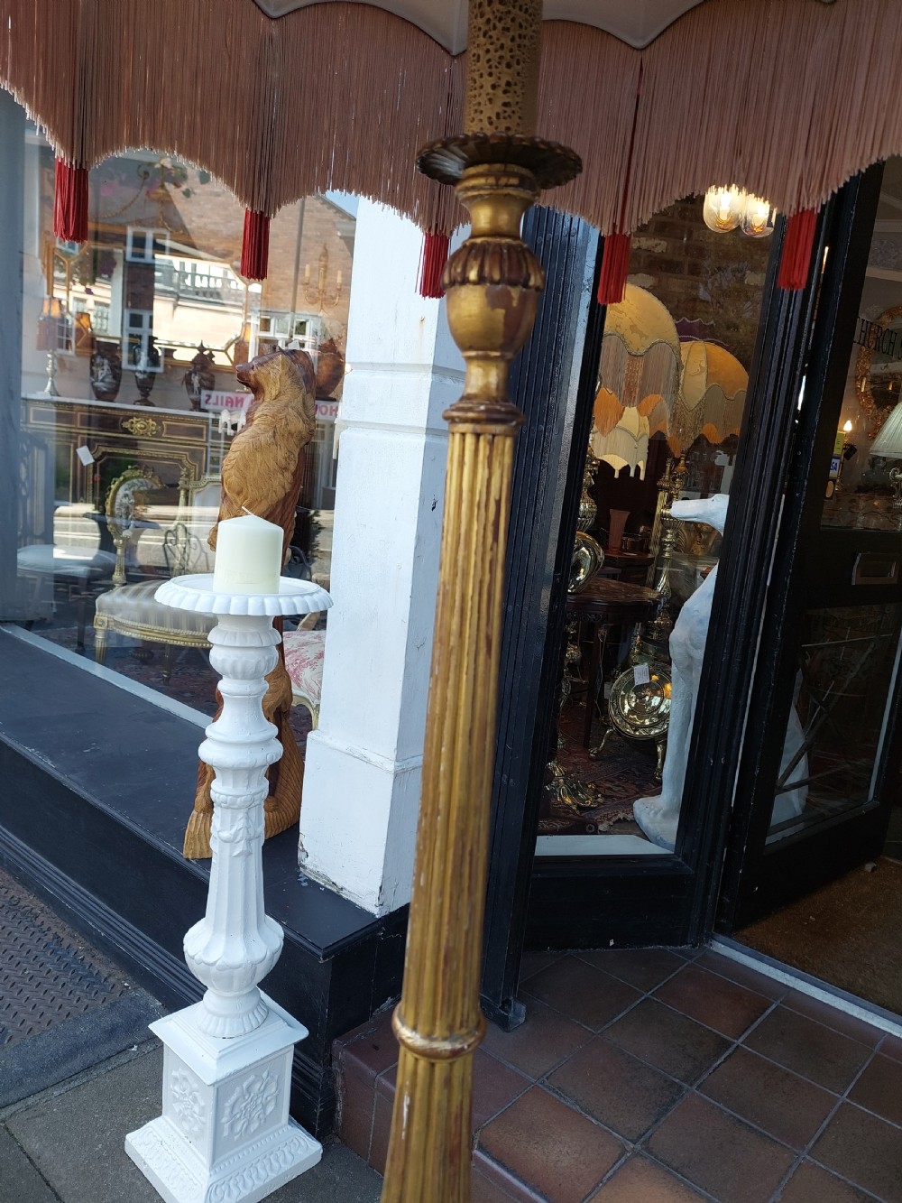 A tall Neoclassical giltwood standard lamp featuring a reeded column, an urn knop, carved tripod legs, and a fabric shade with tasselled fringe. View VI