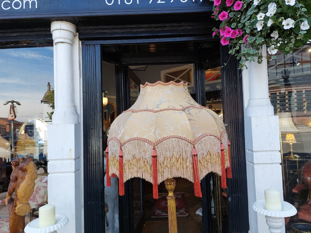 A tall Neoclassical giltwood standard lamp featuring a reeded column, an urn knop, carved tripod legs, and a fabric shade with tasselled fringe. View VIII