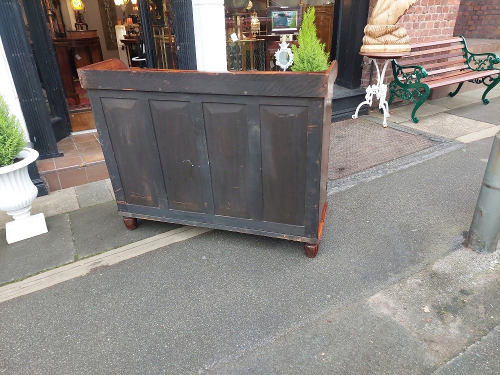 A Regency Goncalo Alves side cabinet featuring two pleated light fabric panel doors flanked by fluted columns on turned feet. View X