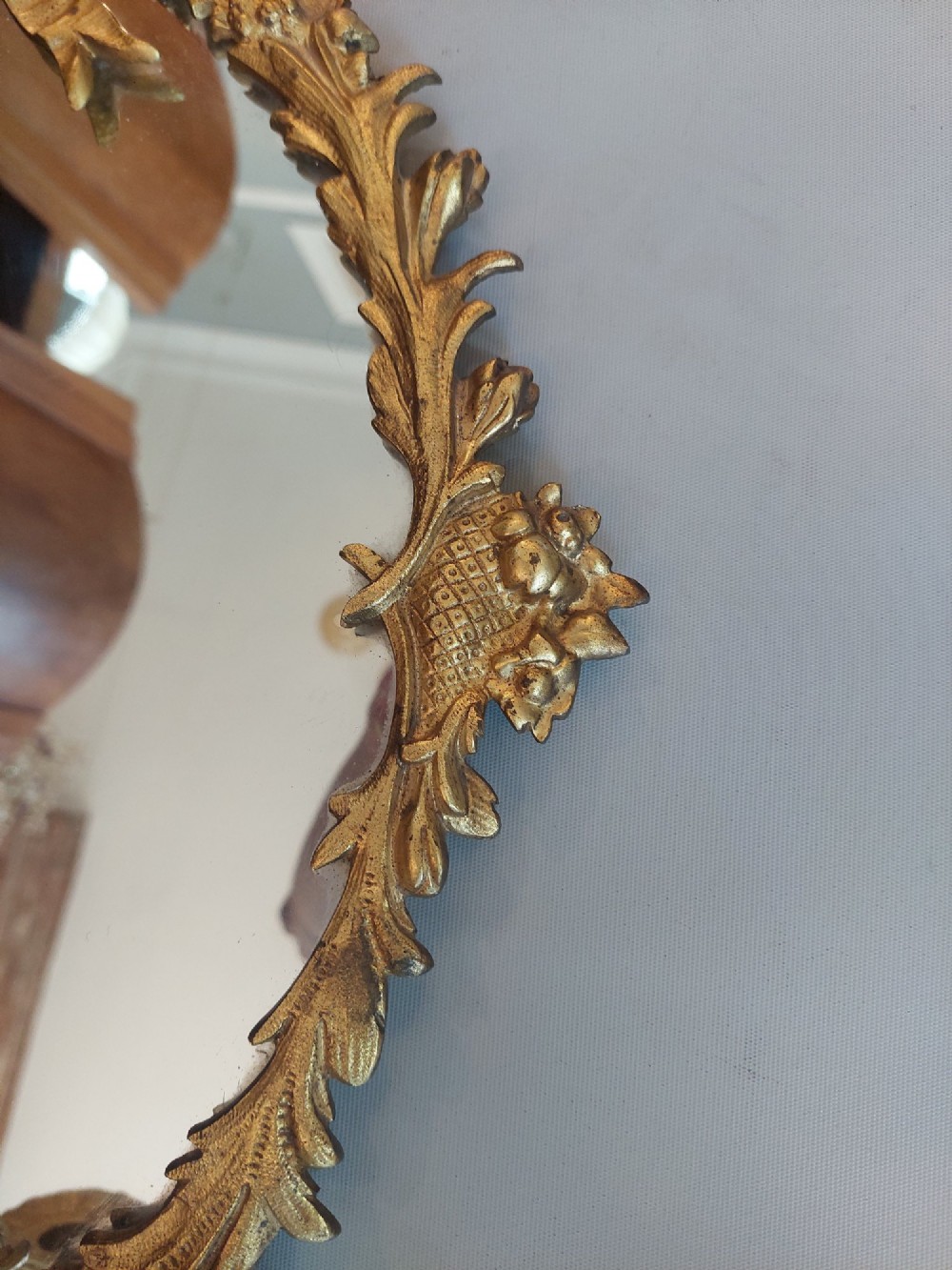A pair of early 20th-century oval gilt metal wall mirrors with ribbon-tied crests and three candle branches. View III