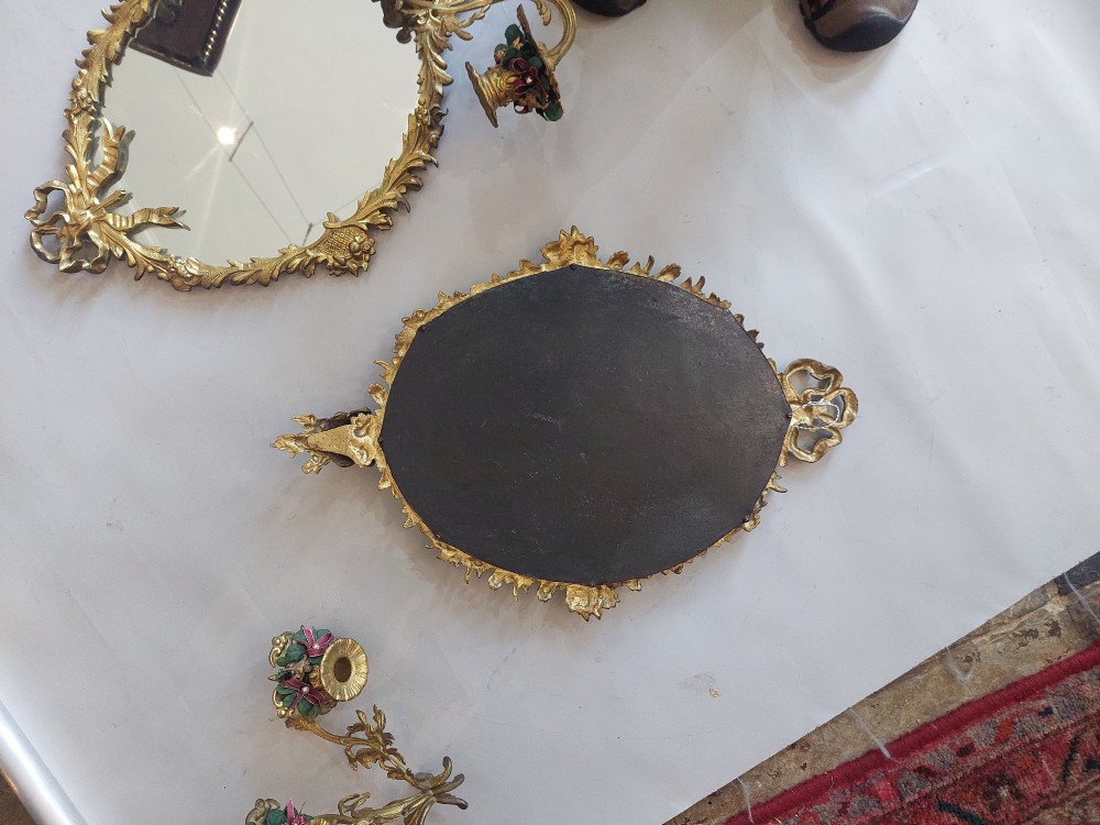 A pair of early 20th-century oval gilt metal wall mirrors with ribbon-tied crests and three candle branches. View VIII