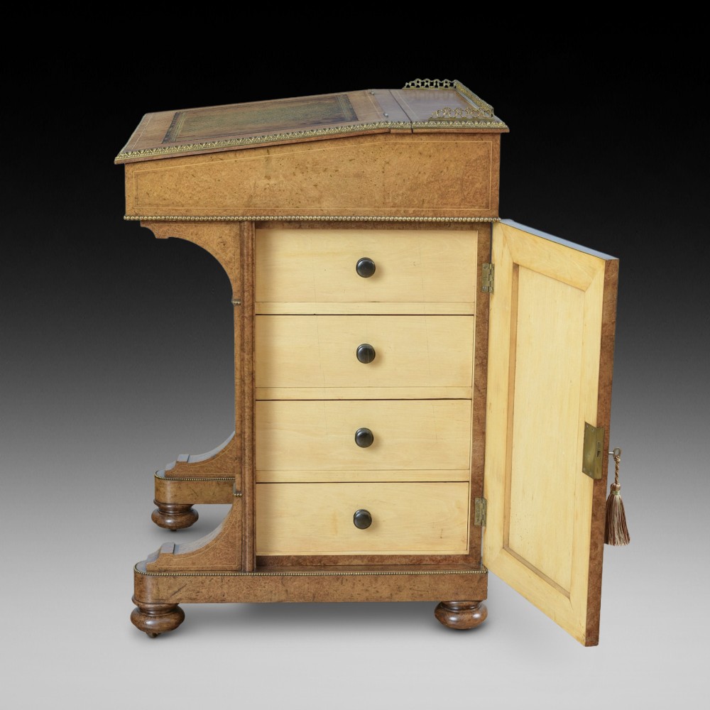 A mid-19th-century Victorian Davenport desk crafted from amboyna veneer with a sloping leather writing surface, decorative brass gallery, and side cupboard door. View II