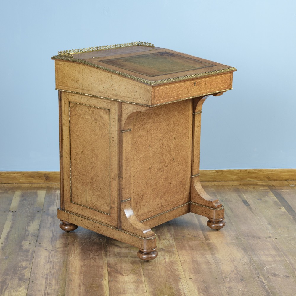A mid-19th-century Victorian Davenport desk crafted from amboyna veneer with a sloping leather writing surface, decorative brass gallery, and side cupboard door. View III