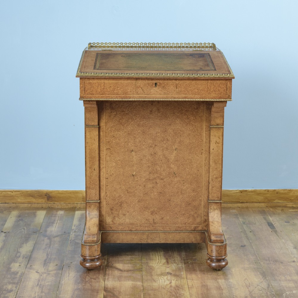 A mid-19th-century Victorian Davenport desk crafted from amboyna veneer with a sloping leather writing surface, decorative brass gallery, and side cupboard door. View IV