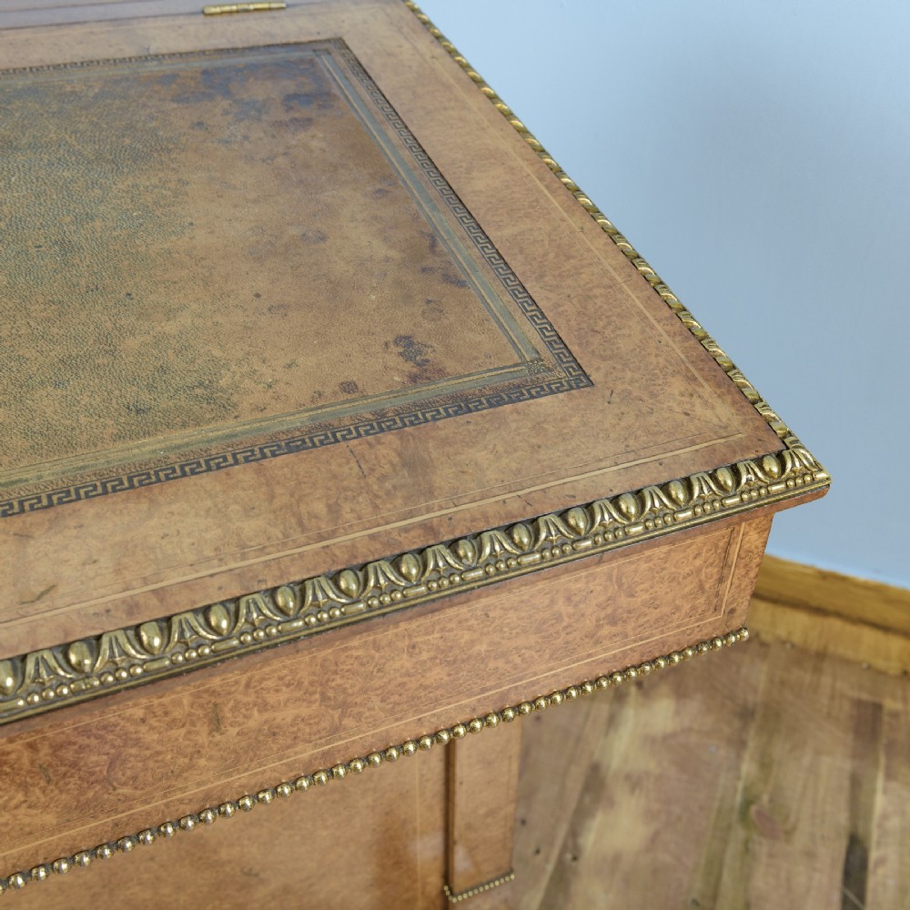 A mid-19th-century Victorian Davenport desk crafted from amboyna veneer with a sloping leather writing surface, decorative brass gallery, and side cupboard door. View VI