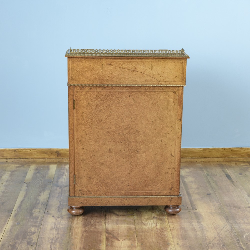 A mid-19th-century Victorian Davenport desk crafted from amboyna veneer with a sloping leather writing surface, decorative brass gallery, and side cupboard door. View VIII