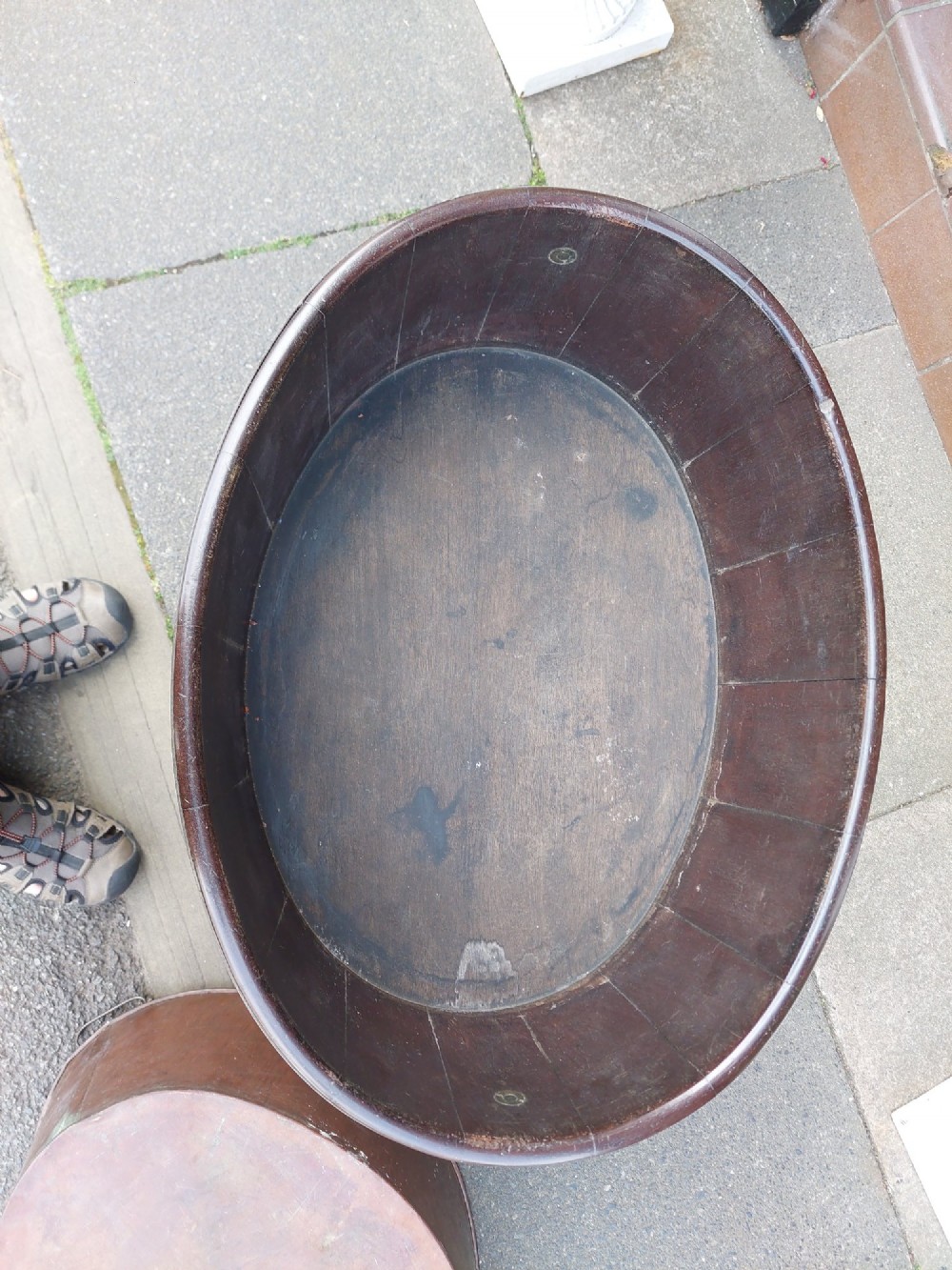 An 18th-century oval dark mahogany wine cooler with brass binding straps and carrying handles, elevated on a four-legged stand with castors. View VI