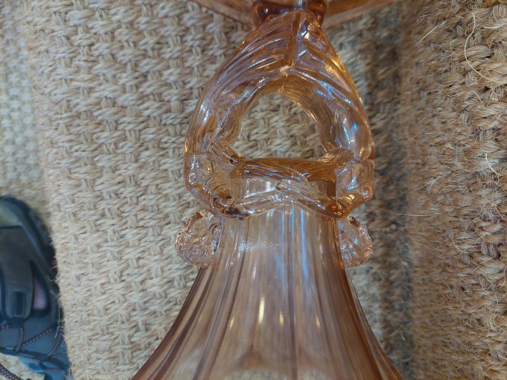 A translucent pink pressed glass vase featuring a flared fluted top supported by a figural stem and a hexagonal base. View IV