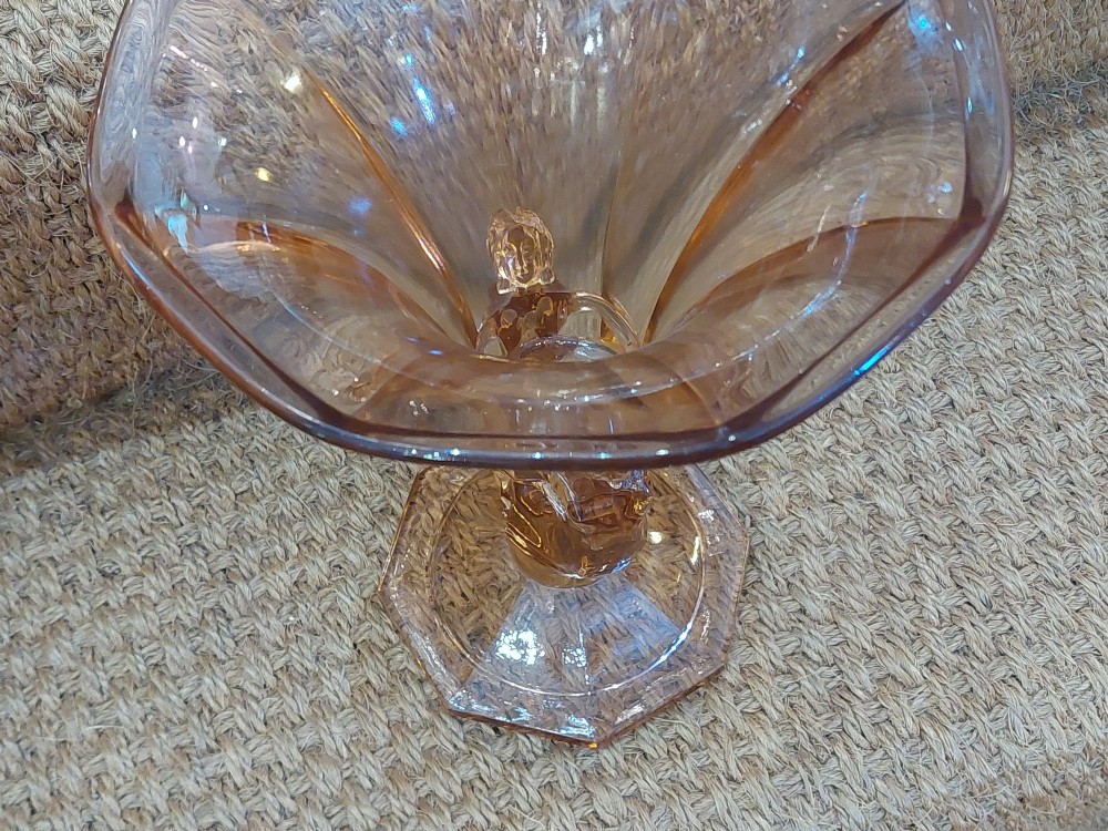 A translucent pink pressed glass vase featuring a flared fluted top supported by a figural stem and a hexagonal base. View X
