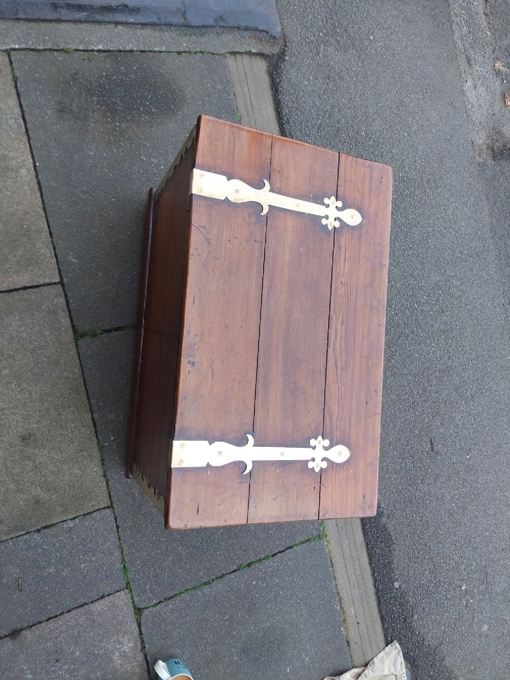 A rectangular Victorian pitch pine storage trunk featuring reinforced brass corner straps, strap hinges, side handles, and a keyhole with a black tassel. View II