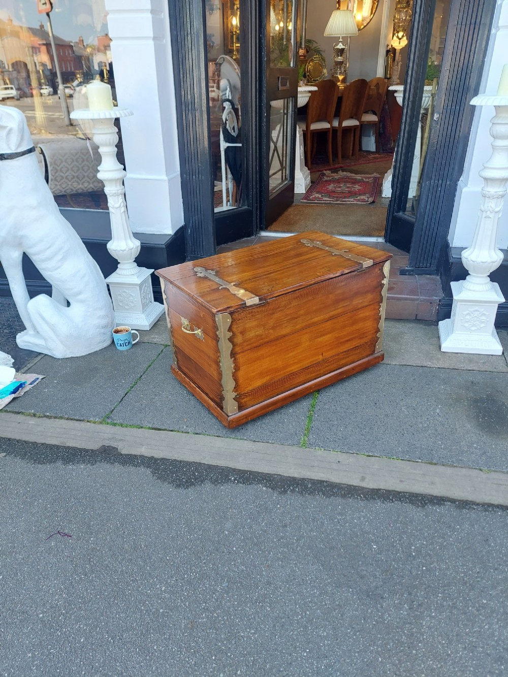 A rectangular Victorian pitch pine storage trunk featuring reinforced brass corner straps, strap hinges, side handles, and a keyhole with a black tassel. View VII
