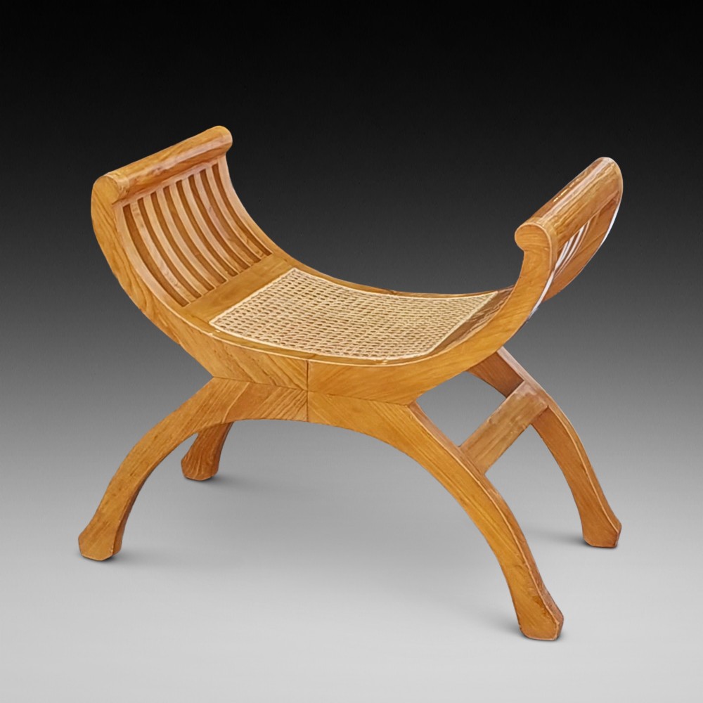 A late nineteenth-century golden satinwood dressing table stool featuring a curved X-frame design, slatted scroll armrests, and a central woven cane seat.