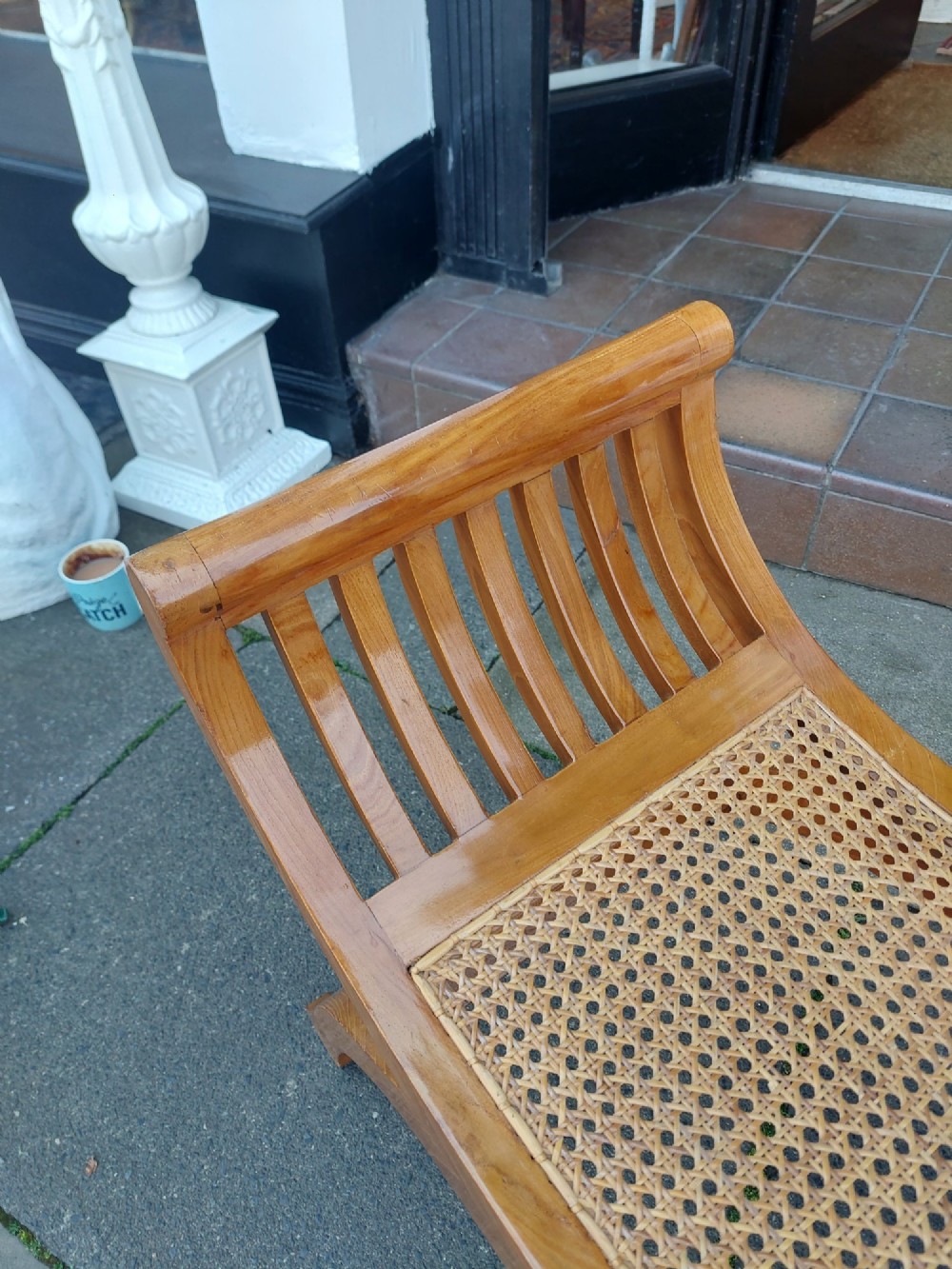 A late nineteenth-century golden satinwood dressing table stool featuring a curved X-frame design, slatted scroll armrests, and a central woven cane seat. View II